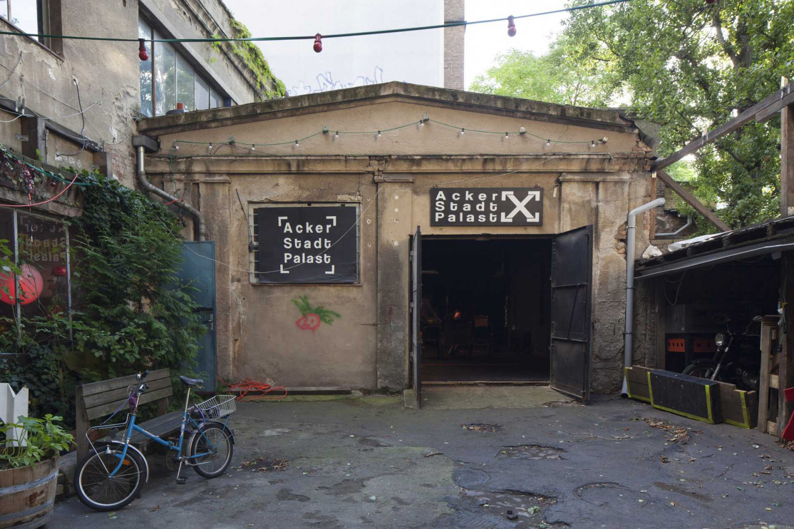 Der Eingang der Bühne vom Acker Stadt Palast, ein beiges altes einstockiges Gebäude mit offenen Türen.