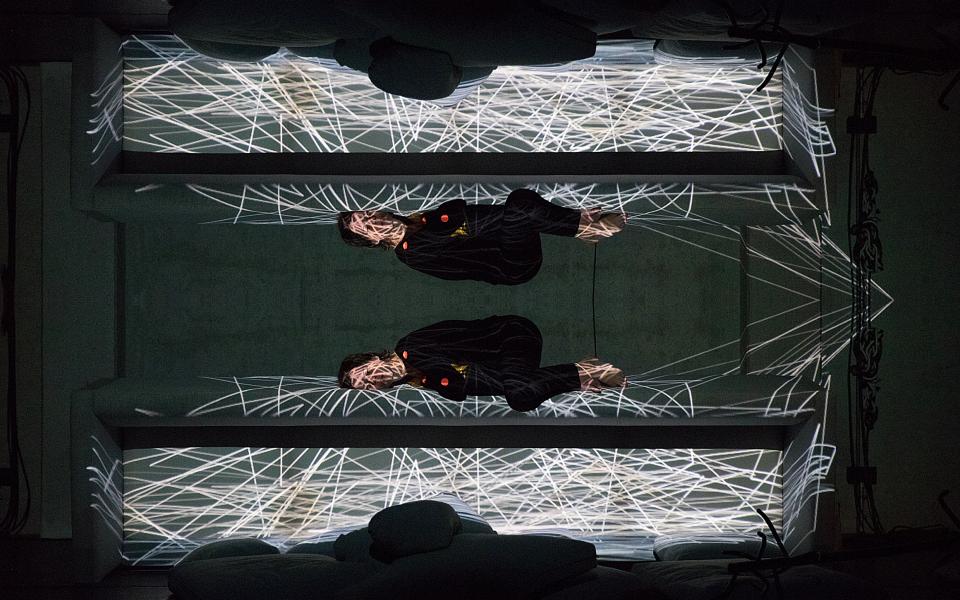 Eine Frau liegt in einem digitalen Netz aus Licht.